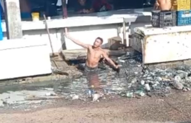 Revoltado, homem limpa bueiro com as próprias mãos em feira de Manacapuru; vídeo