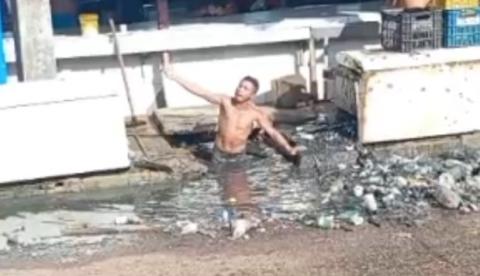 Revoltado, homem limpa bueiro com as próprias mãos em feira de Manacapuru; vídeo