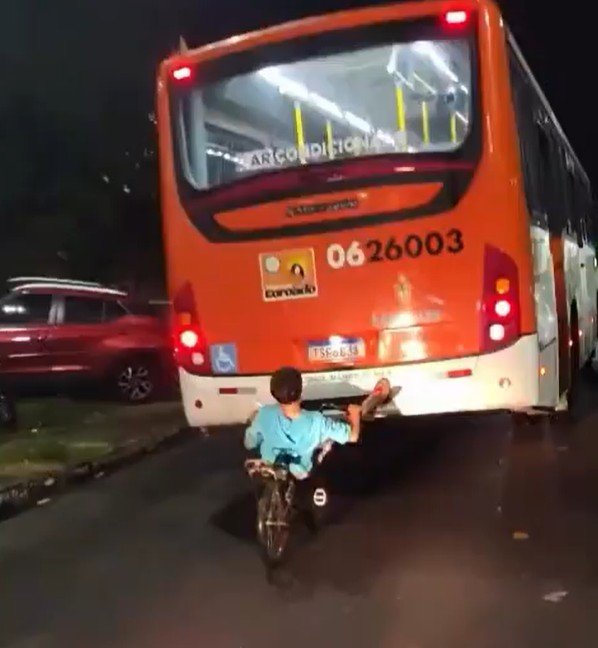 Garoto é flagrado pendurado pelos pés na traseira de ônibus em movimento em Manaus