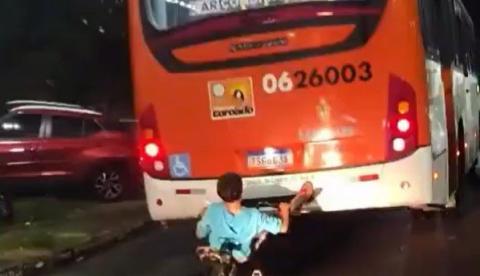 Garoto é flagrado pendurado pelos pés na traseira de ônibus em movimento em Manaus