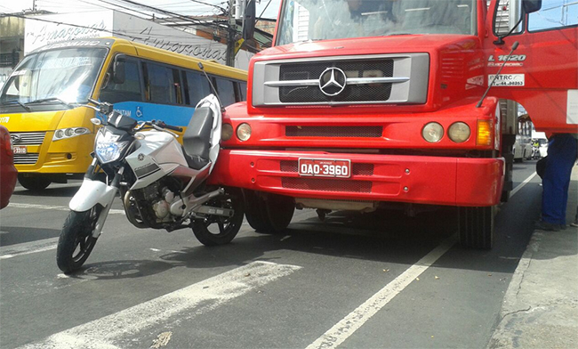 Caminhão bate e moto fica engatada