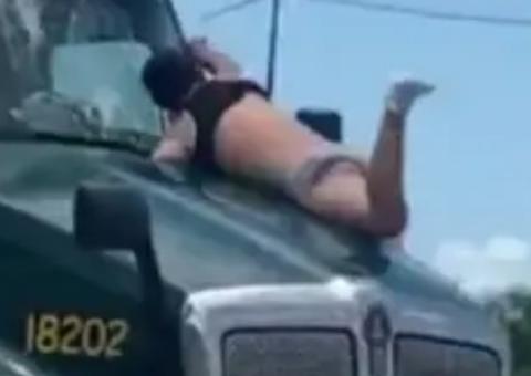 Caminhão é flagrado trafegando com homem de cueca pendurado no capô
