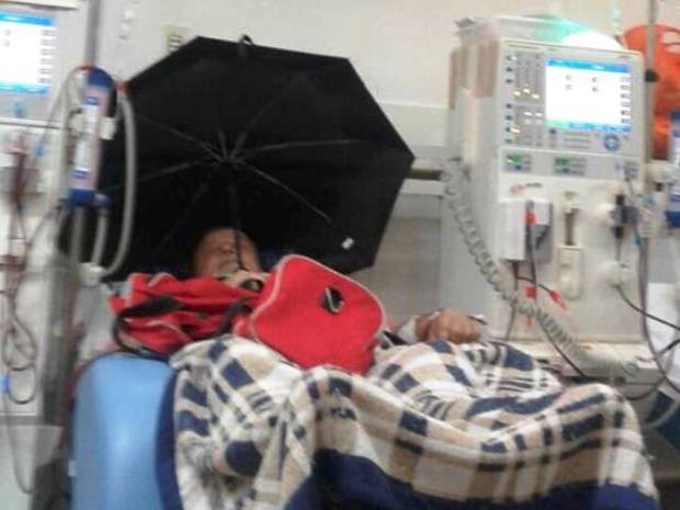 Idoso usa guarda-chuva dentro de hospital para se livrar de goteira  