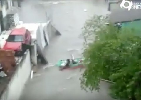 Moradores criam 'bote' inusitado para navegar durante inundação em rua de Manaus