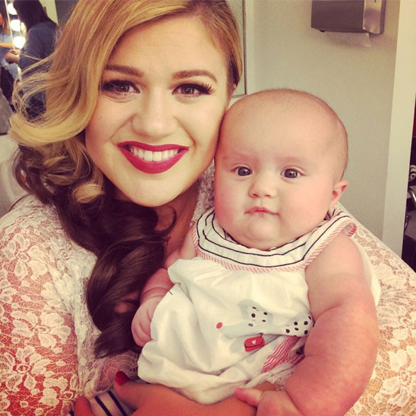 Kelly Clarkson posa com a filha em dia de gravação