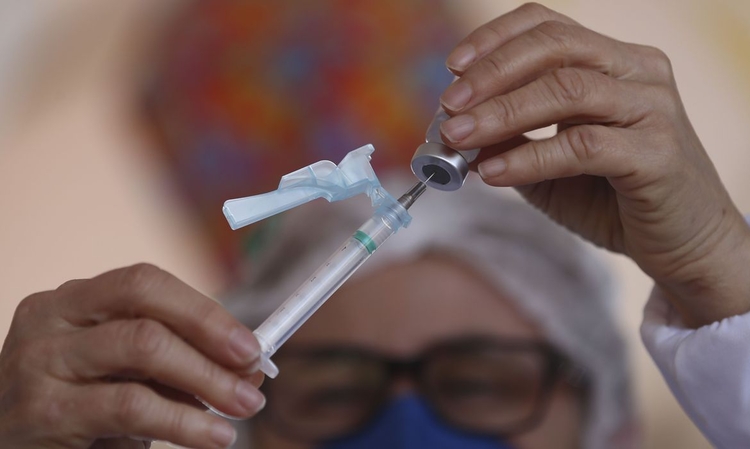 Mulher segura seringa com dose de vacina. Foto: Divulgação/ EBC
