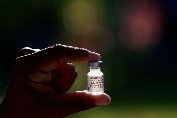 Agente de saúde segura frasco com doses de vacina. Foto: Divulgação/ Prefeitura do Rio de Janeiro