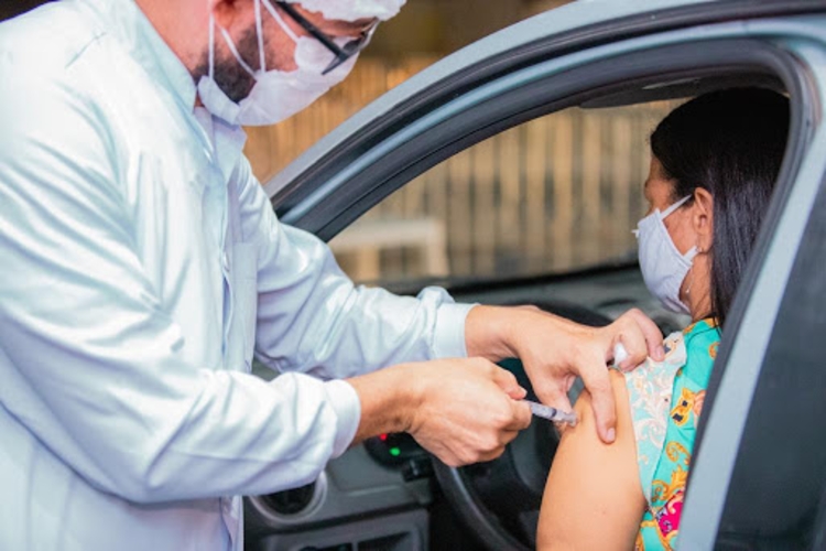 Mulher recebe dose de vacina dentro de carro. Foto: Divulgação/ Secom