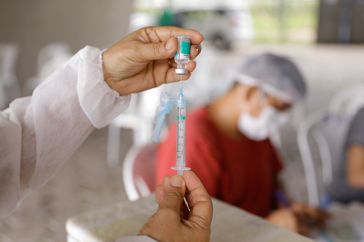 Mulher segura vacina com dose contra covid. Foto: Divulgação/ Semcom