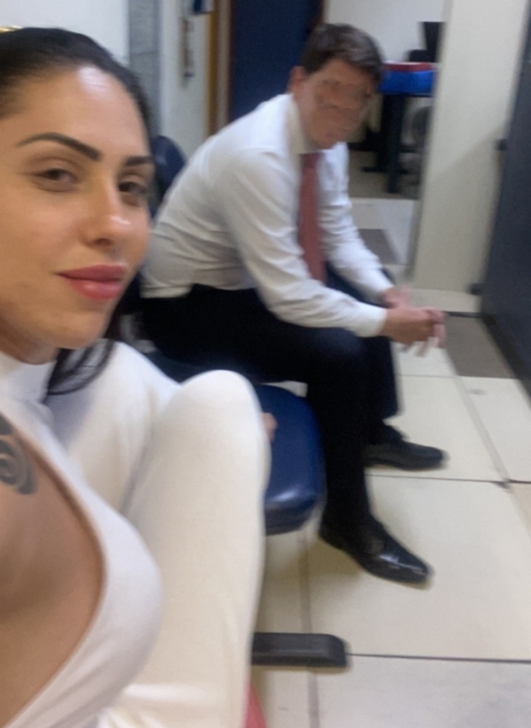 Monique Medeiros em selfie tirada na delegacia em dia de depoimento. Foto foi achada pela polícia no celular dela: pernas sobre o banco e sorriso esboçado no rosto  - Foto: Reprodução