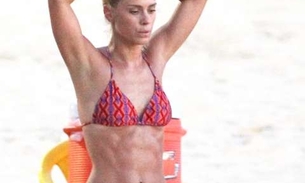  Carolina Dieckmann exibe barriga sarada em dia de treino na praia