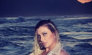 Modelo Luciane Hoepers posa com seios à mostra na praia