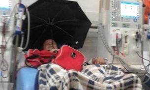 Idoso usa guarda-chuva dentro de hospital para se livrar de goteira  