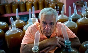 Homem usa camisinhas para fechar galões de vinho para vinificação