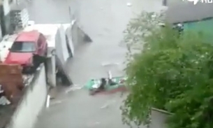 Moradores criam 'bote' inusitado para navegar durante inundação em rua de Manaus