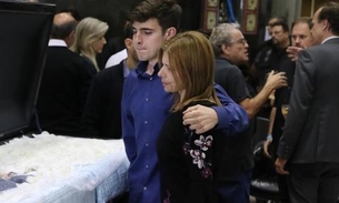 Abraçado à mãe, filho de Gugu Liberato deixa lembrança no caixão do pai