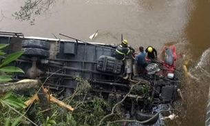 Caminhão cai em rio e motorista é resgatado com água no pescoço