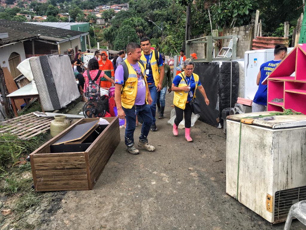 Moradores tentam resgatar móveis após deslizamento de terra