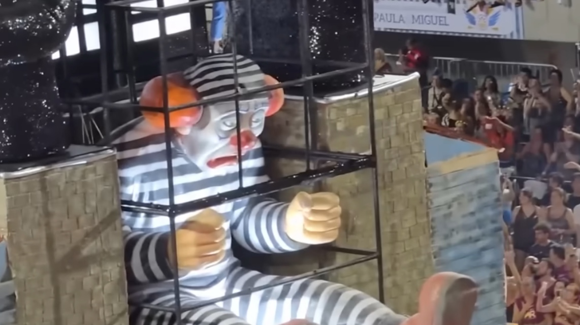 Um dos carros alegóricos trouxe uma representação provocativa de Bolsonaro como um palhaço detido, utilizando uma tornozeleira eletrônica danificada.