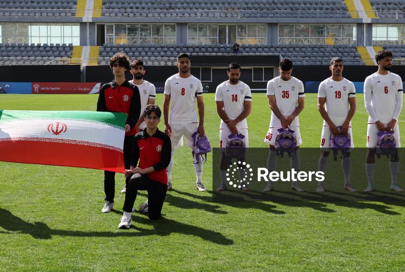 Jogadores iranianos de futebol seguram mochilas escolares em protesto por meninas mortas