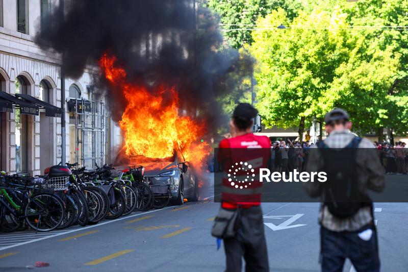 Manifestantes quebram janelas e incendeiam um Tesla durante marcha contra o G7 em Genebra