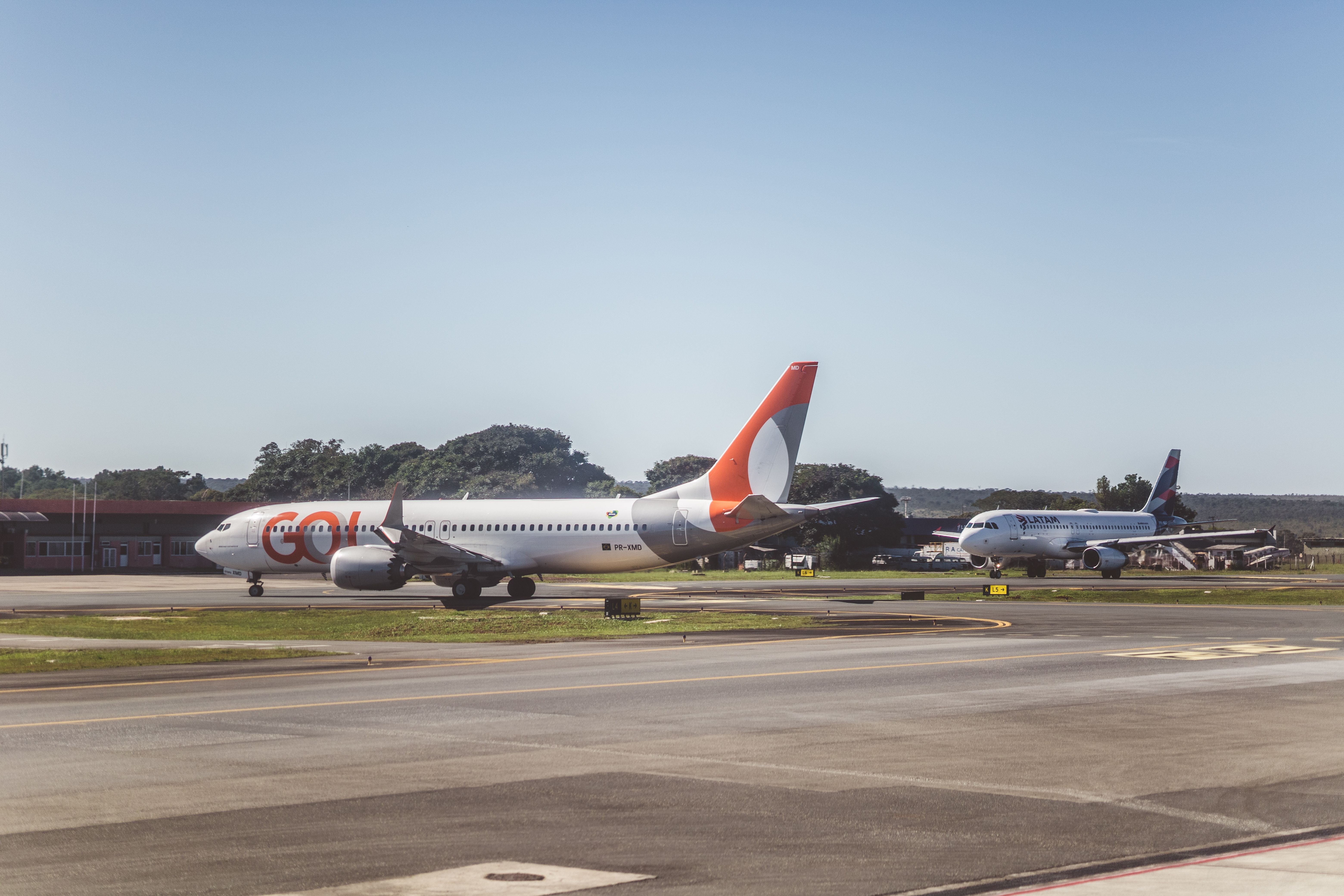 Airliners taxiing on a sunny day at an airport, ready for takeoff.